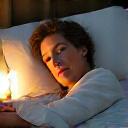 Una persona che dorme serenamente in un letto confortevole, simbolo di recupero notturno e relax.